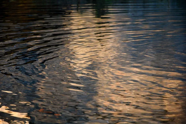 Superfície de água ondulada ao pôr-do-sol — Fotografia de Stock