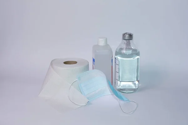 Toalettpapirruller Med Beskyttelsesmaske Desinfeksjonsmiddelflaske Saltflaske Hvit Bakgrunn Med Kopiplass – stockfoto