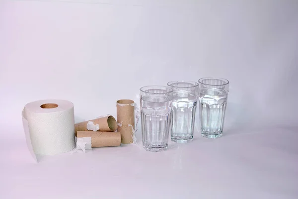 Drink a lot in case of diarrhea - Full and empty toilet paper rolls with three glasses of water and with copy space