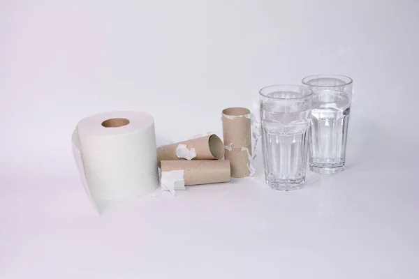 Drink a lot in case of diarrhea - Full and empty toilet paper rolls with two glasses of water with copy space