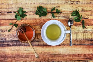 Hastalık ve hastalık kavramı ve alternatif tıp ile tedavi edilmeleri. Yırtık nane yaprakları ve salvia. Kahverengi bal ve tahta kaşık. Modern eczacı. Tahta.