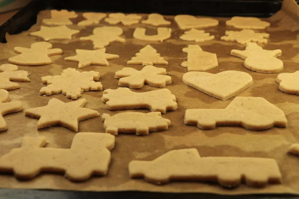 Raw dough for Christmas cookies and cookie cutters shaped glove, Christmas star, snowman, pig, gingerbread man. Concept of winter holidays and work together. Baby Jesus or Santa claus coming soon. — Stock Photo, Image