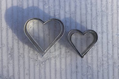 Donmuş plastik tahtadaki şekerler için Noel formu. Kalbin metal şekli için detaylar. Noel tatiline hazırlanın. Önyargı kaybı ve refah tatili kavramı