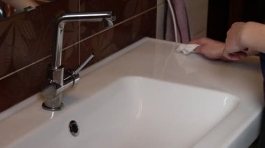Kız lavaboyu bakterilerden temizliyor. Kadınlar koronavirüsten dolayı lavaboyu dezenfekte eder. Covid-19. Önemli olan temizlik ve ellerinizi yeterince yıkamak..
