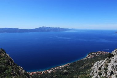 Hırvatistan 'ın Split-Dalmaçya İlçesi' ndeki Hvar adası ve Korula 'da sabah saatlerinde büyüleyici manzara. Gradac City yakınlarında çılgın bir kaya. Sahil boyunca yüksek dağlar. Dağcı ya da deneyimli yürüyüşçü için ideal
