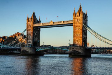 Thames nehri boyunca uzanan muhteşem ve tarihi Tower Köprüsü günbatımı ve mavi gökyüzü boyunca. Tower Bridge birleşik bir bazkül ve asma köprüdür. Köprü iki köprü kulesinden oluşur..