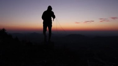 Sporcu, gün batımında tepenin zirvesinde, Czech manzarasıyla ip atlayarak atlıyor. Sporcu gün doğumunda antrenman yapıyor. Biraz pratik yapmak için harika bir zaman..