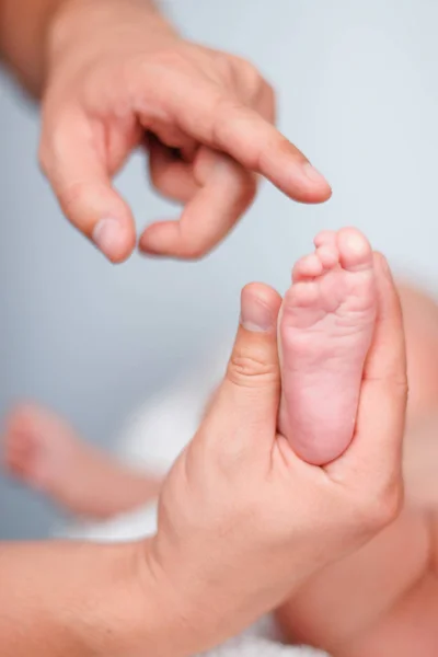Mjuka nyfödda barn fötter mot en vit filt. — Stockfoto