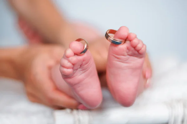 Vigselringar på tårna av nyfödda barnets ben — Stockfoto