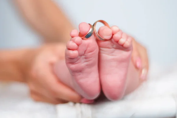 Vigselringar på tårna av nyfödda barnets ben — Stockfoto