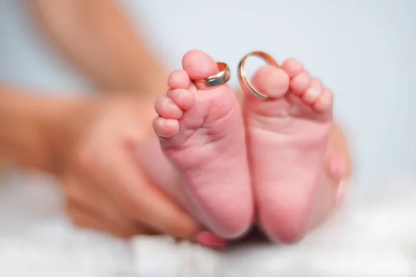 Anéis de casamento nos dedos dos pés das pernas do bebê recém-nascido — Fotografia de Stock