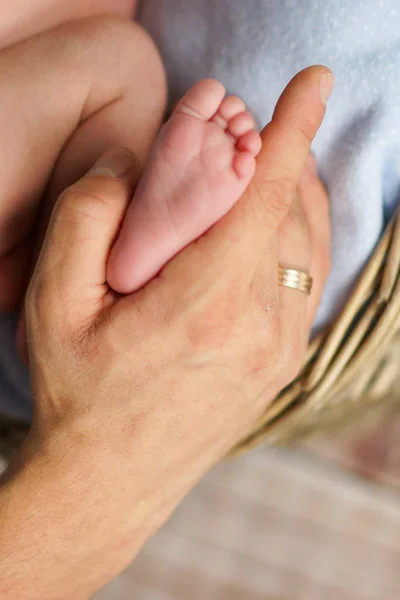 A mão do pai segura o pé de um recém-nascido — Fotografia de Stock