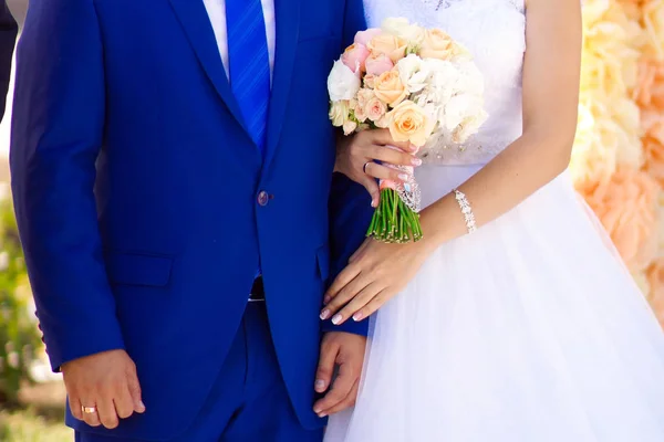 Giovane sposa in un bel vestito che tiene un mazzo in mano — Foto Stock