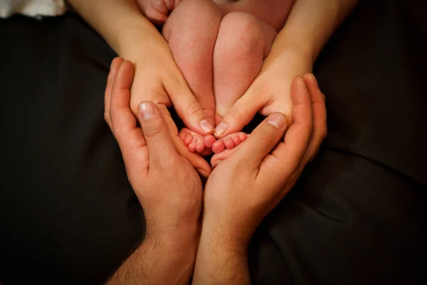 아빠의 그의 어머니의 손과 아기 발에 손. 행복 한 가족 개념입니다. 출산의 아름 다운 개념 이미지 — 스톡 사진