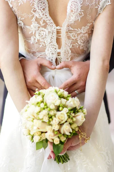 Noiva jovem em um belo vestido segurando um buquê nas mãos — Fotografia de Stock