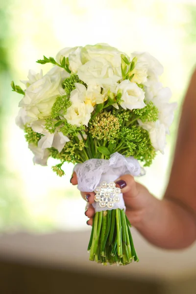 Jeune mariée dans une belle robe tenant un bouquet dans les mains — Photo