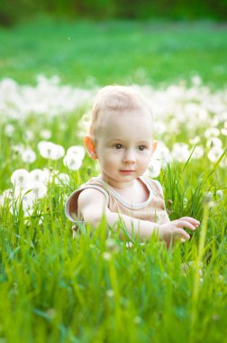 Yeşil çim günbatımında oynayan çocuk