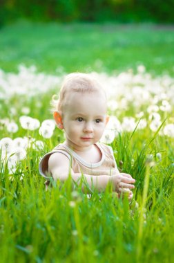 Yeşil çim günbatımında oynayan çocuk