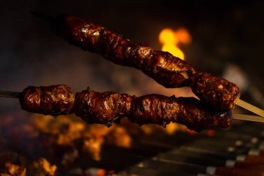 Domuz etinin bir şiş bir mangal üzerinde kızartma. Dönüm etin kömürlerin üzerine. İştah açıcı şiş kebap. Lezzetli Barbekü.