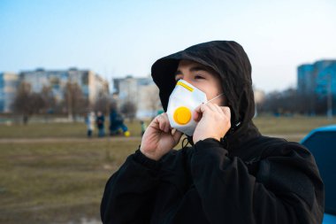 Orta keskin. Şehrin arka planında koruyucu maskeli bir adam var. Virüse karşı savaş. Acil durum. Salgın. Ukrayna. Koronavirüs