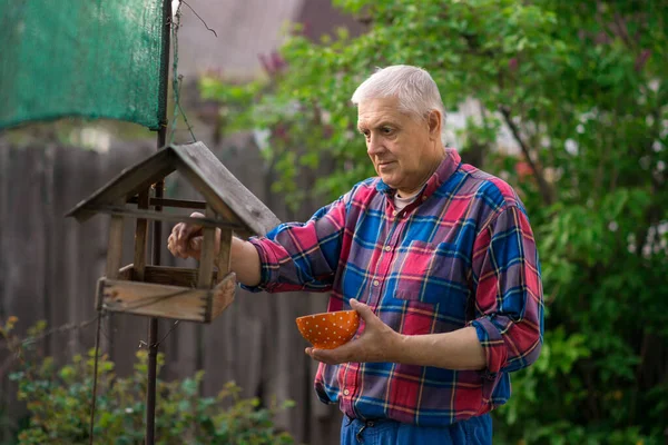 Viejo Granjero Sostiene Tazón Comida Para Pájaros Alimenta Los Pájaros — Foto de Stock