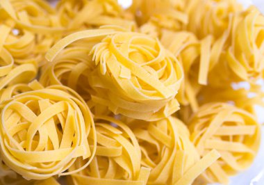 Pişmemiş fettucine yuva makarna dokusu arka plan, afiş