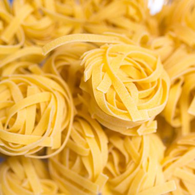 Pişmemiş fettucine yuva makarna dokusu arka plan, afiş