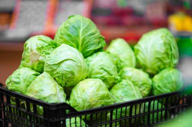 Plastik bir kutuda beyaz ve yeşil lahana. Karton kutularda lahana. Organik sebze işi.