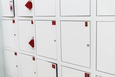 Süpermarkette numaraları ve anahtarları olan beyaz hücre dolapları.