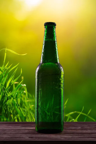 Flaska Grön Färg Med Droppar Dryck Utan Etikett Solnedgång Bakgrund — Stockfoto