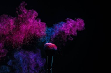Parlak bir toz paletinde kozmetik fırçalar. Makyaj altında renkli bir patlama. desing