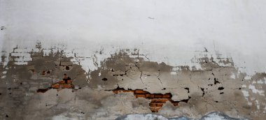 Sanat, beyaz ve gri renklerle kaplı eski beton duvarı çatlattı. Çimento yüzeyi arka planda kırıldı. Olay yerini kapat. Yapısal dış hasar kirli doku retro.İnşaat detayları.