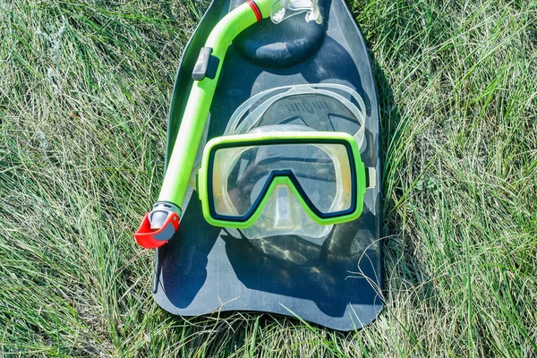 草の上に寝そべっている水中マスクとフリッパーのダイバー装置 — ストック写真