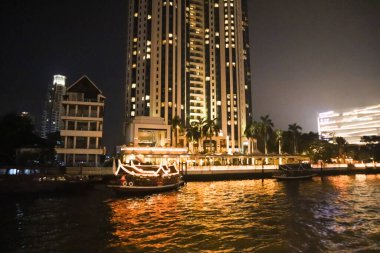 Bangkok 'taki Chao Phraya Nehri' nde setin kenarında. Seyahat için iki teknesi var. Akşamları şehir manzarası. Asya 'da zenci hayatı