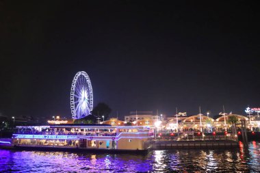 Bangkok 'taki Chao Phraya Nehri' nin kıyısında bir sürat teknesi. Akşamları şehir manzarası. Asya 'da zenci hayatı