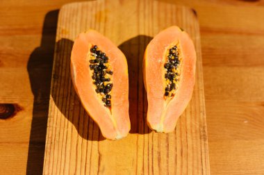 Üstten Görünüm yarı ahşap arka plan üzerinde taze turuncu papaya meyve kesti. Closeup düz yatıyordu