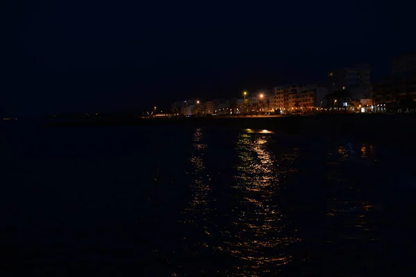 Luz borrosa de la ciudad bokeh con reflejo en el fondo de agua — Foto de Stock