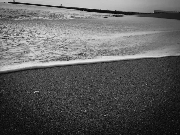 Nero astratto spiaggia di sabbia naturale primo piano, sfondo costa vulcanica. Superficie dello spazio per testo — Foto Stock