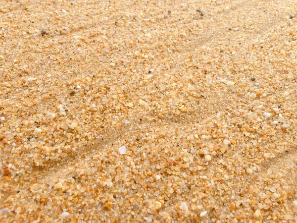 Abstracte natuurlijke zandstrand close-up, achtergrond van de zeekust. Oppervlak van de ruimte voor tekst — Stockfoto