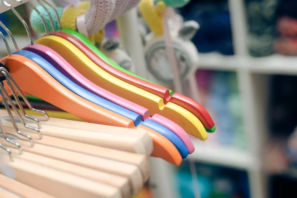 Photo closeup of colorful hangers hanging on rack