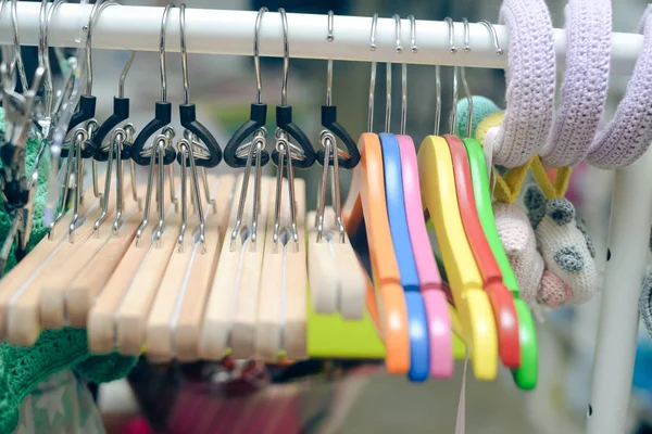 Photo closeup of colorful hangers hanging on rack