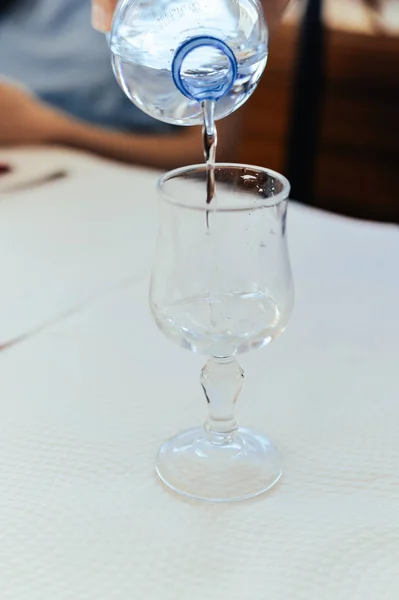 Water Wordt Gegoten Een Glas Wijn Een Natuurlijke Lichte Achtergrond — Stockfoto