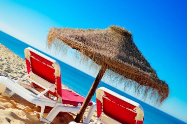 Tatil plaj şezlong ve şemsiye gölgelik okyanus açık havada arka plan üzerinde.