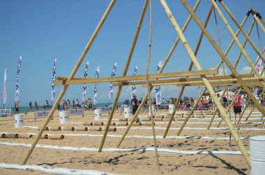 Algarve Portugal 29 April 2017: Tribal Clash takes place on Quarteira beach. Team of people having fun working compiting together. Sporty dedication friendship building activity. Wellbeing lifestyle clipart