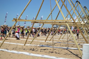 Algarve Portugal 29 April 2017: Tribal Clash takes place on Quarteira beach. Team of people having fun working compiting together. Sporty dedication friendship building activity. Wellbeing lifestyle clipart