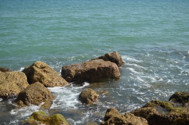 Kayalarla okyanusun güneşli panoramik manzarası, deniz manzarası doğal arka plan.