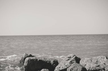 Kayalarla okyanusun güneşli panoramik manzarası, deniz manzarası doğal arka plan.