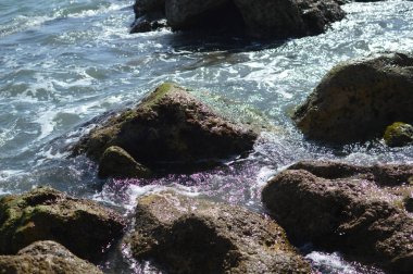 Kayalarla okyanusun güneşli panoramik manzarası, deniz manzarası doğal arka plan.