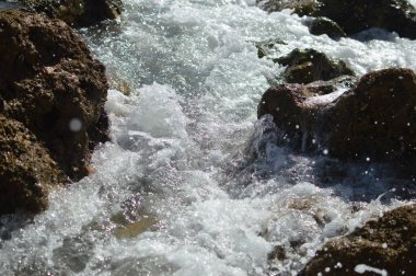 Kayalarla okyanusun güneşli panoramik manzarası, deniz manzarası doğal arka plan.