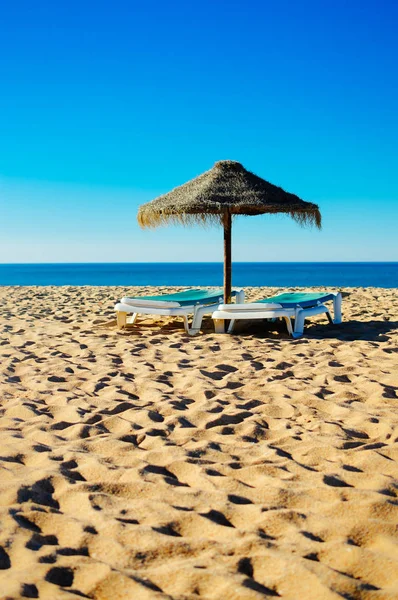 Cielo azul y sombrilla de playa silla en la hermosa costa del océano tropical, soleado al aire libre fondo escénico — Foto de Stock